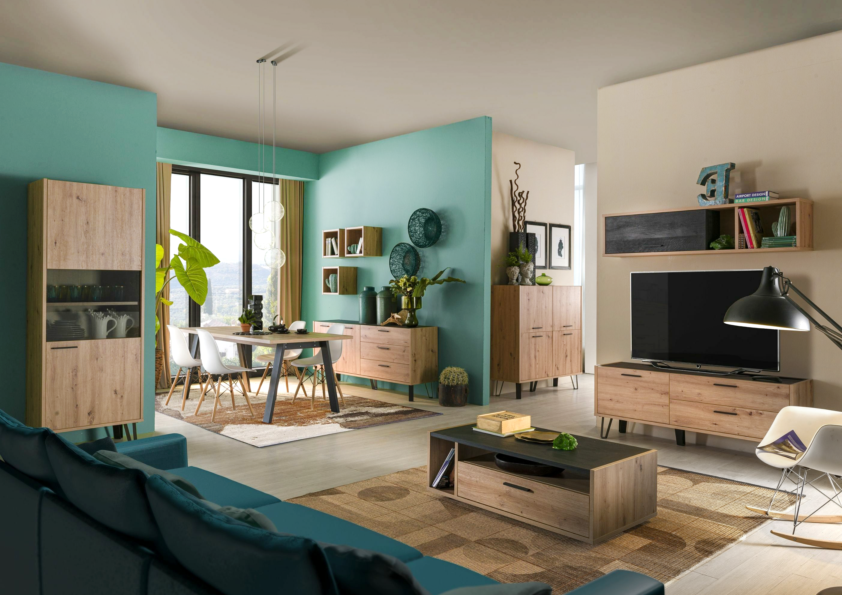 Un séjour qui donne envie d'y passer son samedi grâce à une décoration chaleureuse et apaisante. Ses murs clairs ou bleu canard mettent bien en avant les meubles de la collection MILOS, au décor en bois clair et au design contemporain. 